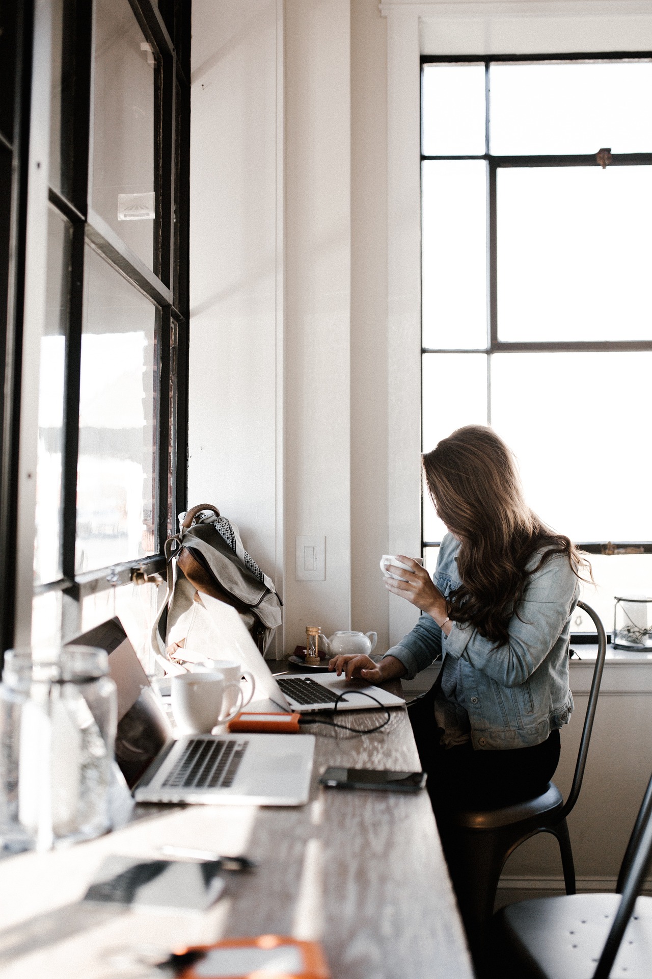 Kristina working at a laptop by a sunlit window